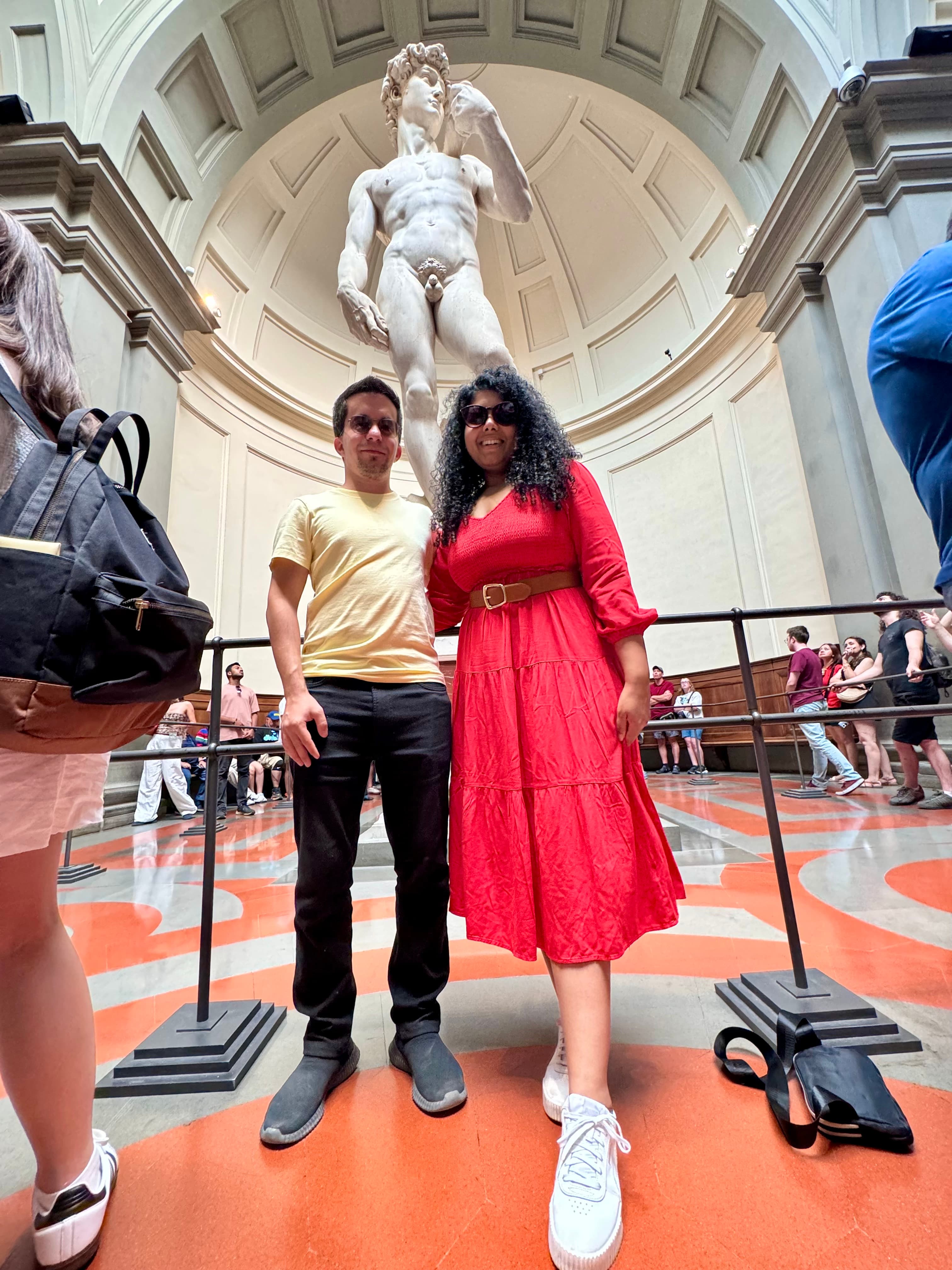 Gayatri and Oleg standing beneath Michelangelo's David in Florence